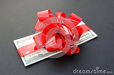 Money dollars wrapped in a bow on a gift Stock Photo