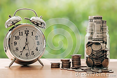 Money in glass with retro alarm clock for time to money saving for retirement concept.money for future Stock Photo