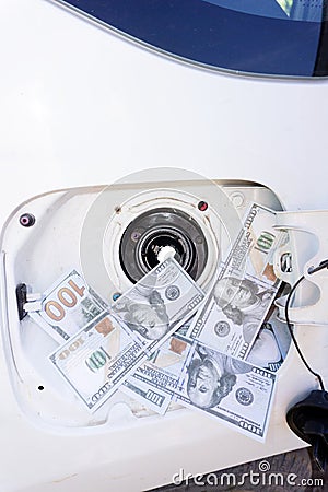 Money going down the gas tank hundred Stock Photo