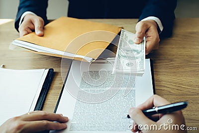 Money in the hands of businessmen who are submitting to entrepreneurs to force the signing of contract documents about corruption Stock Photo