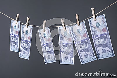 Close-up of money, dried on the ropes, fastened with clothespins. The concept of drying money. On a gray background Money Stock Photo