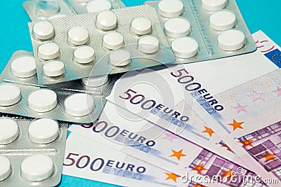 Money pills. Medicine pills on euro bills on a blue background. Covid-19 coronavirus pills are in euro money. The Stock Photo