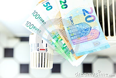 Money on a radiator symbolizes the expensive heating costs Stock Photo