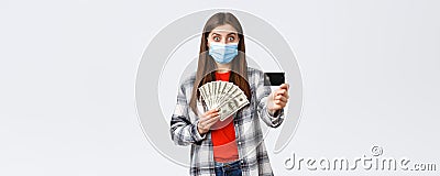 Money transfer, investment, covid-19 pandemic and working from home concept. Surprised young woman showing credit card Stock Photo