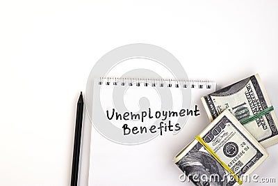 Money in a wad and a white notebook marked Unemployment benefits Stock Photo