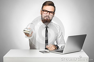 Money are yours! Portrait of handsome richman bearded young big boss in white shirt and black tie are sitting in office giving Stock Photo