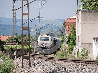 Locomotive of the Renfe company pulling freight wagons leaves a curve in the track Editorial Stock Photo