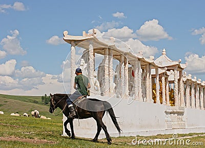 Mongolian horse rider in the desert on beautiful brown horse near asian abcient temple. Editorial Stock Photo