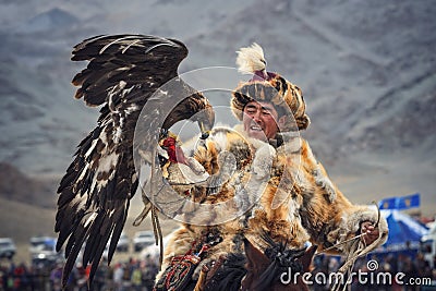 Mongolia. Traditional Golden Eagle Festival. Unknown Mongolian Hunter Berkutchi On Horse With Golden Eagle. Falconry In West Mon Editorial Stock Photo