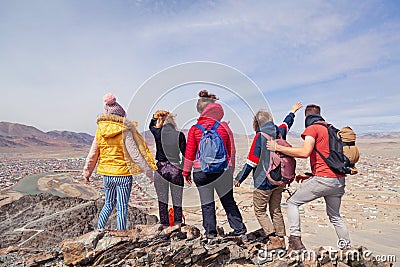 Mongolia Ulgii 2019-05-04 Tourist group in colored clothes with backpacks hiking, climbing, walking together with guide stand on Editorial Stock Photo