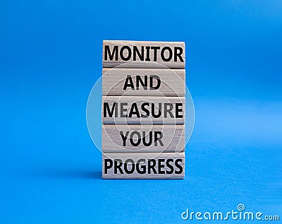 Monitor and Measure your Progress symbol. Wooden blocks with words Monitor and Measure your Progress. Beautiful blue background. Stock Photo
