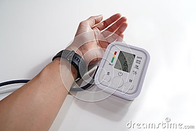 Monitoring blood pressure of patients using upper arm blood pressure monitor in the clinic examination room. Stock Photo