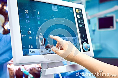 Monitoring patient`s vital sign in operating room. doctor cheking at patient`s vital signs. Cardiogram monitor during Stock Photo