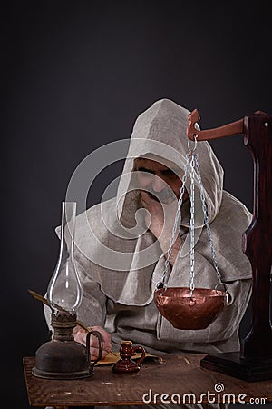 A monk alchemist is engaged in science, writing ancient manuscripts on birch bark Stock Photo
