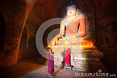 Monk in Bagan old town pray a buddha statue with candle Stock Photo