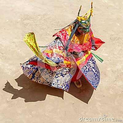 Monk in a bull deity mask with ritual dagger phurpa performs a religious masked and costumed Cham dance of Tibetan Buddhism Stock Photo