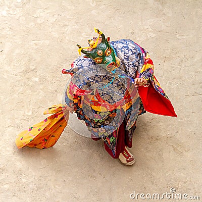 Monk in a bull deity mask with ritual dagger phurpa performs a religious masked and costumed Cham dance of Tibetan Buddhism Stock Photo