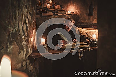 Monk chronicler writes an ancient manuscript Stock Photo