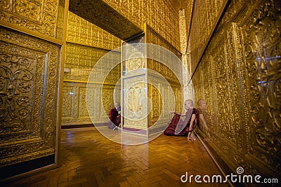 Monk in red robes prays inside temple Editorial Stock Photo