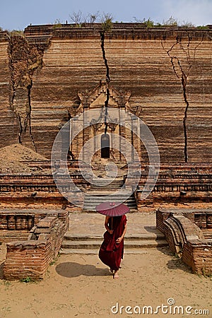 A monk walking at the broken temple in Mandalay, Myanmar Editorial Stock Photo