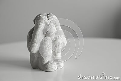 A monkey figurine that sits and closes its eyes with its hands. I don't see anything Stock Photo