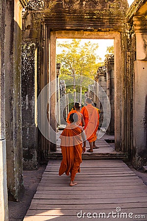 The monks in the ancient stone faces of Bayon temple, Angkor Editorial Stock Photo