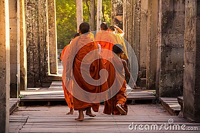 The monks in the ancient stone faces of Bayon temple, Angkor Editorial Stock Photo