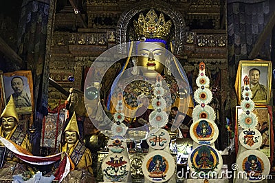 Monks stand before a Golden Buddha statue in Pelkor Chode Monastery in Tibet Editorial Stock Photo