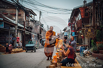 Monks walk for alms in the morning on Walking Street, Chiang Khan District Editorial Stock Photo