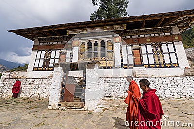 Monks walking past building in Rinpung dzong Editorial Stock Photo