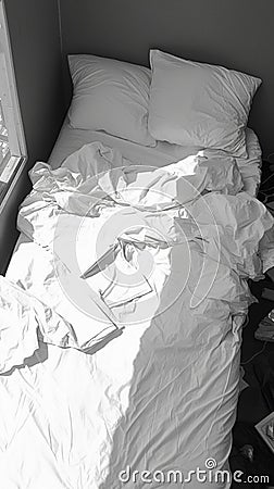 Monochromatic comfort White bedding in disarray, black and white tones Stock Photo