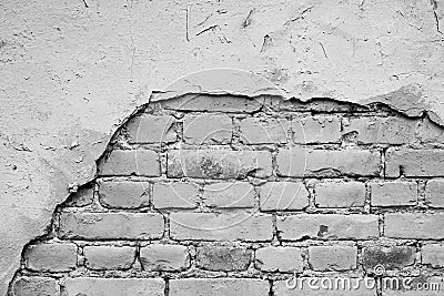 Monochrome brick wall with a hole from the fallen off plaster Stock Photo