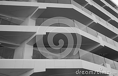 Monochrome detail shot of a facade of a skyscraper. You can see surrounding balconies and large glass windows Stock Photo