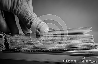 Monochrome image, caucasian man turning old aged book pages Stock Photo