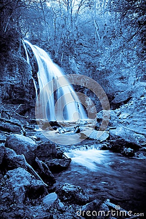 Monochrome photo of a mystical small waterfall Stock Photo