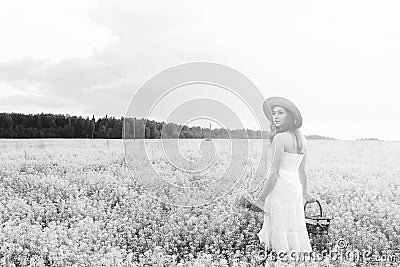 monochrome portrait of young girl in a hat standing in a huge fi Stock Photo