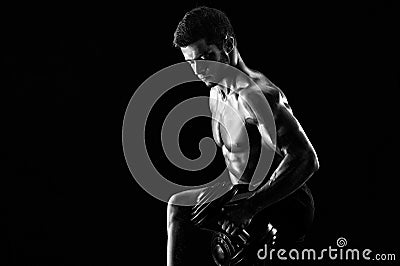 Monochrome shot of an athletic ripped young sportsman with dumbb Stock Photo