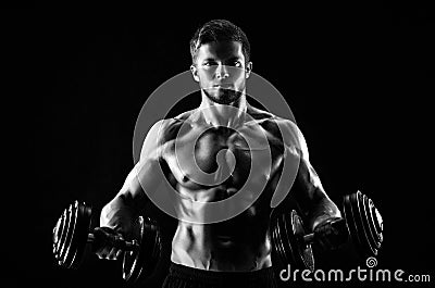 Monochrome shot of an athletic ripped young sportsman with dumbb Stock Photo