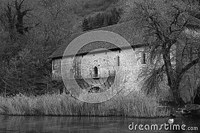 Monochrome shot of a huge old building on the shore of a lake Stock Photo