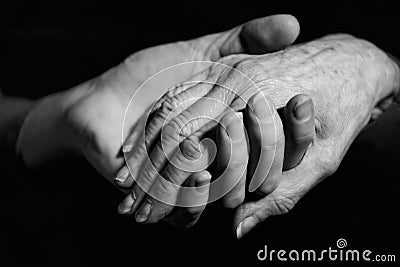 Monochrome Shot Of Young Woman Holding Older Woman's Hand Stock Photo