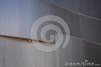 Background or texture in the form of gray covering of facade of the building with illumination. Geometry of lines and minimalism Stock Photo