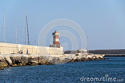 Man fishing in front of lighthouse in Monopoli, Italy Editorial Stock Photo