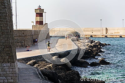 Man fishing in front of lighthouse in Monopoli, Italy Editorial Stock Photo