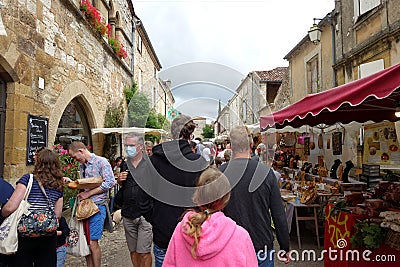 Market stalls set up in the streets of Monpazier, a bastide town in the Lot et Garonne, France Editorial Stock Photo