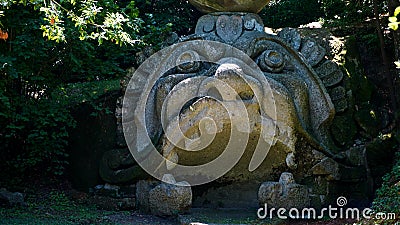 Monstrous sculpture called of Proteus and Glaucus at the Park of the Monsters of Bomarzo among trees and vegetation Editorial Stock Photo