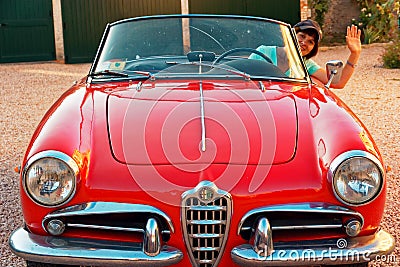 Montagnana, Italy August 27, 2018: Girl driving Retro car Alfa Romeo convertible 1961 ode release. Editorial Stock Photo