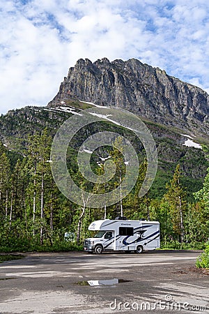 An RV parked at a trailhead parking lot in Glacier National Park Editorial Stock Photo