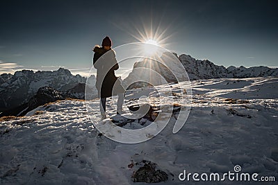 Monte Piana, Italy - January 1, 2019 : silhouette of women hiking in scenic snowy dolomites mountains, with direct sunlight Editorial Stock Photo