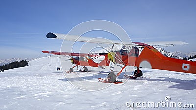 Monte Pora, Bergamo, Italy. A single engined, general aviation red light aircraft parked on a snow covered plateau. Italian Alps Editorial Stock Photo