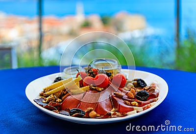Montenegrin Njeguski prsut and cheese antipasto platter with Budva Old Town and Adriatic Sea in Montenegro in background Stock Photo